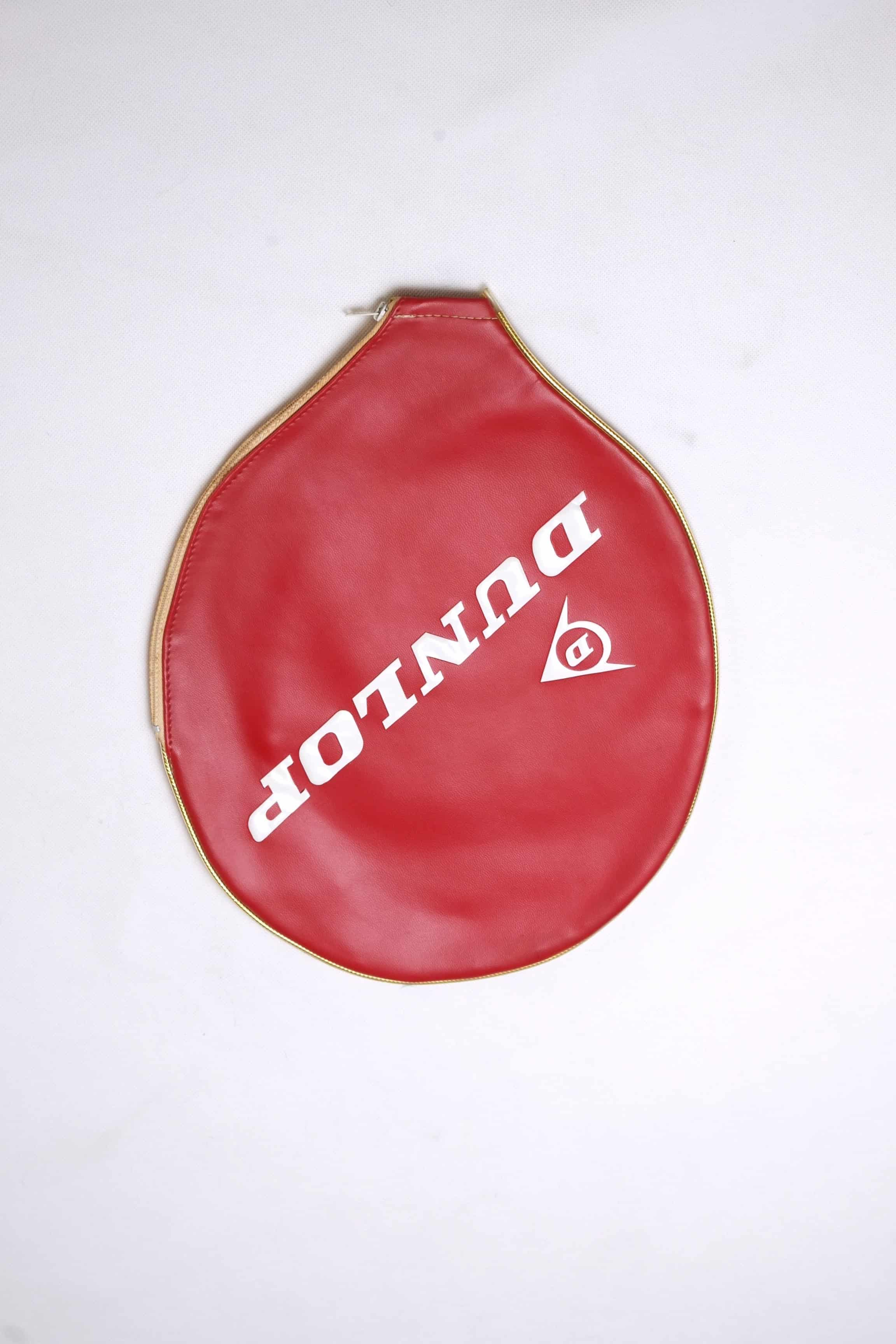Classic red vinyl Dunlop vintage tennis racket cover with a gold-trimmed zipper and diagonal white logo lettering.