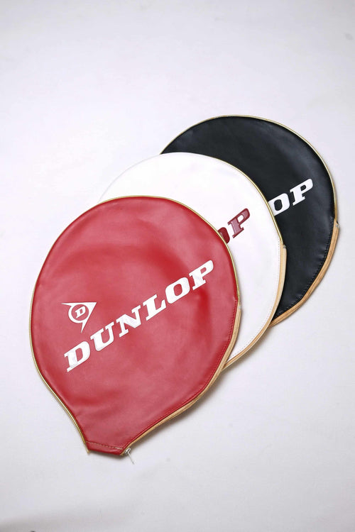 Three vintage vinyl Dunlop tennis racket head covers fanned out in red, white, and black with embossed white branding and gold-toned zipper trims, isolated on a white background.