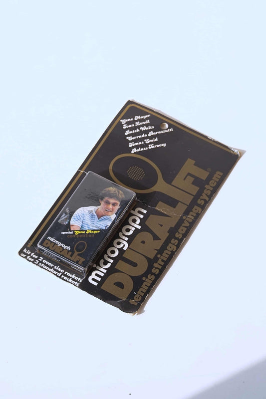 A pack of vintage Duralift Micrograph Tennis String Saver Kit with names of tennis players. The pack is black with brown and white text.