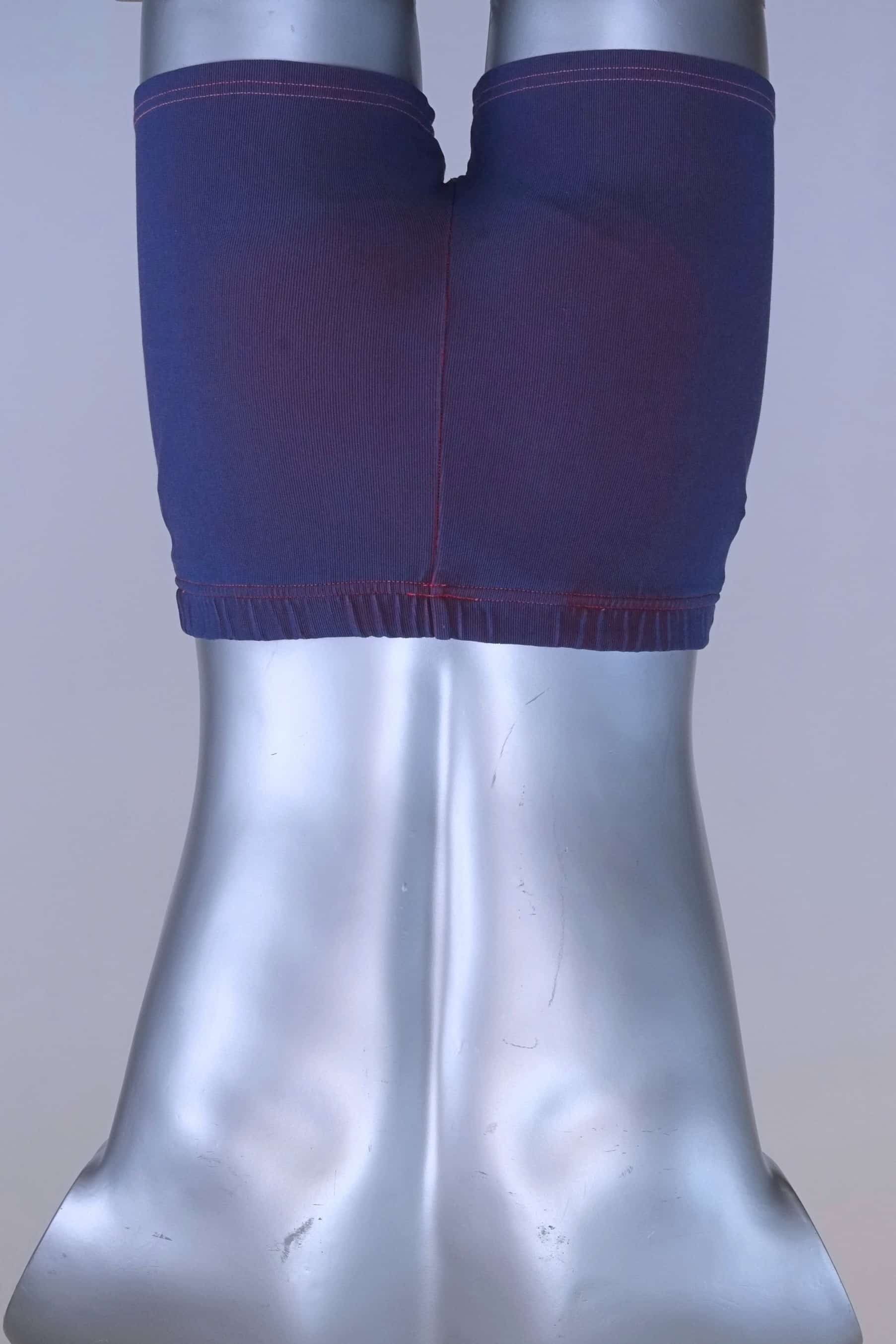 Back view of vintage 90s Ellesse men’s swim trunks in purple ribbed fabric, displayed on mannequin.