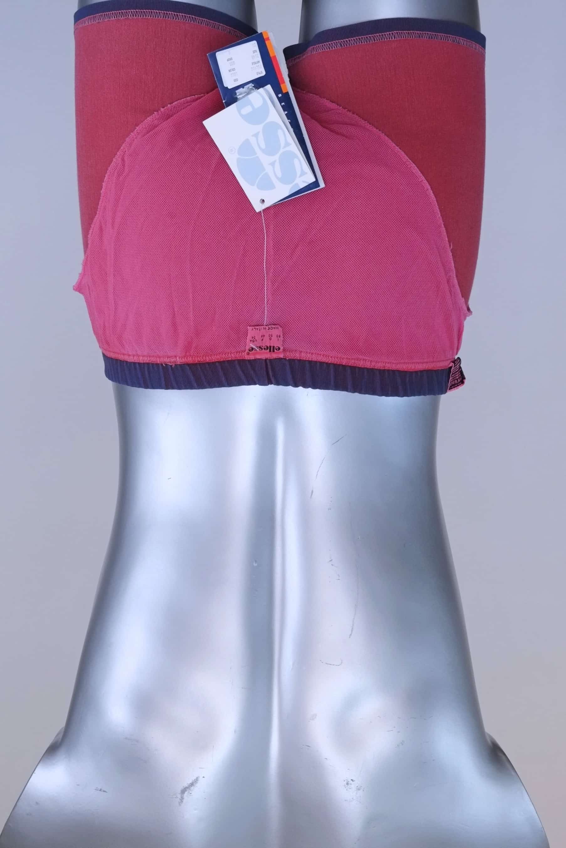 Interior view of vintage Ellesse swim trunks showing pink mesh lining and size tag.