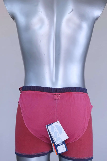Interior view of vintage Ellesse swim trunks showing pink mesh lining and size tag.