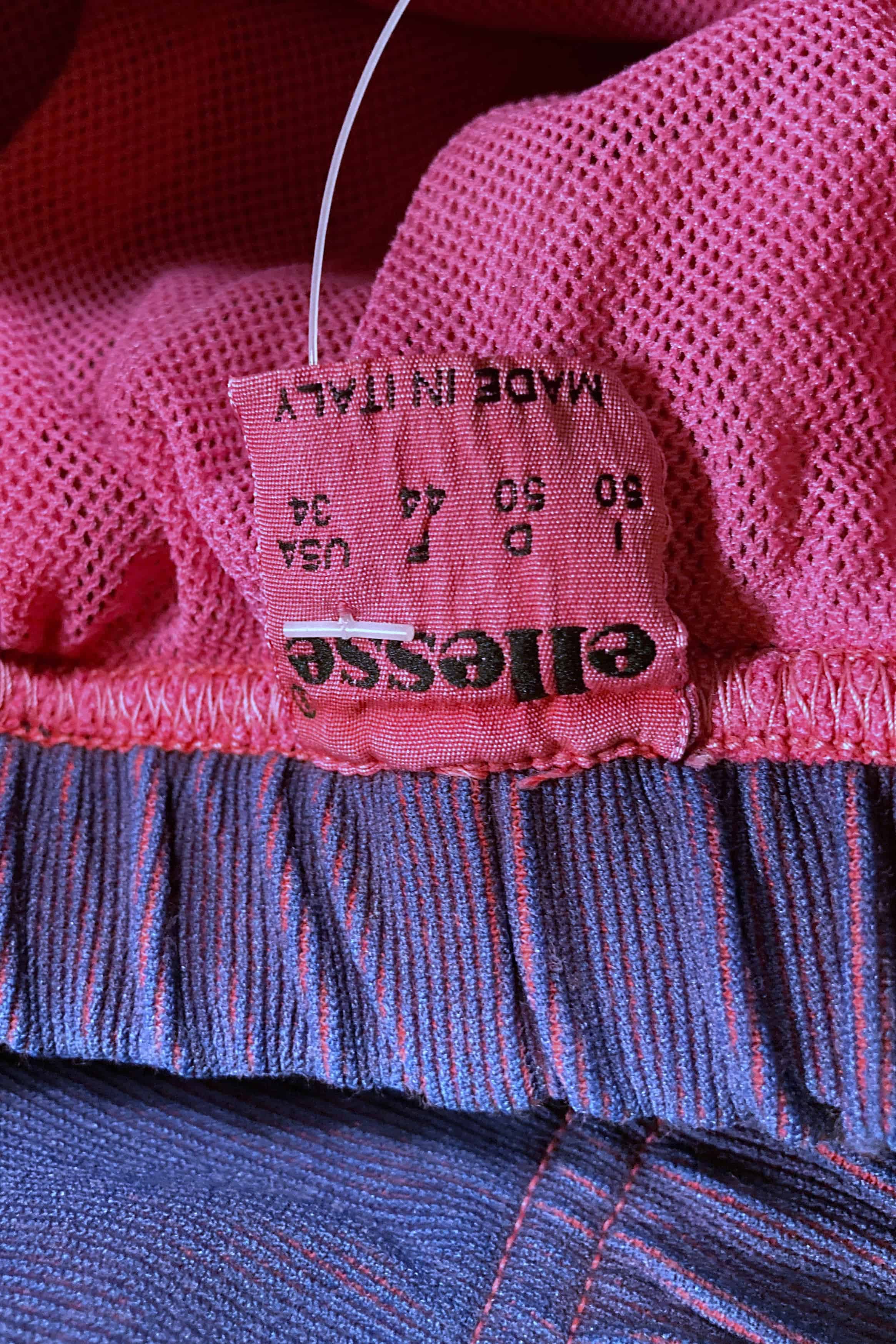 Close-up of pink Ellesse size tag reading 50 Italy, 34 USA, made in Italy.