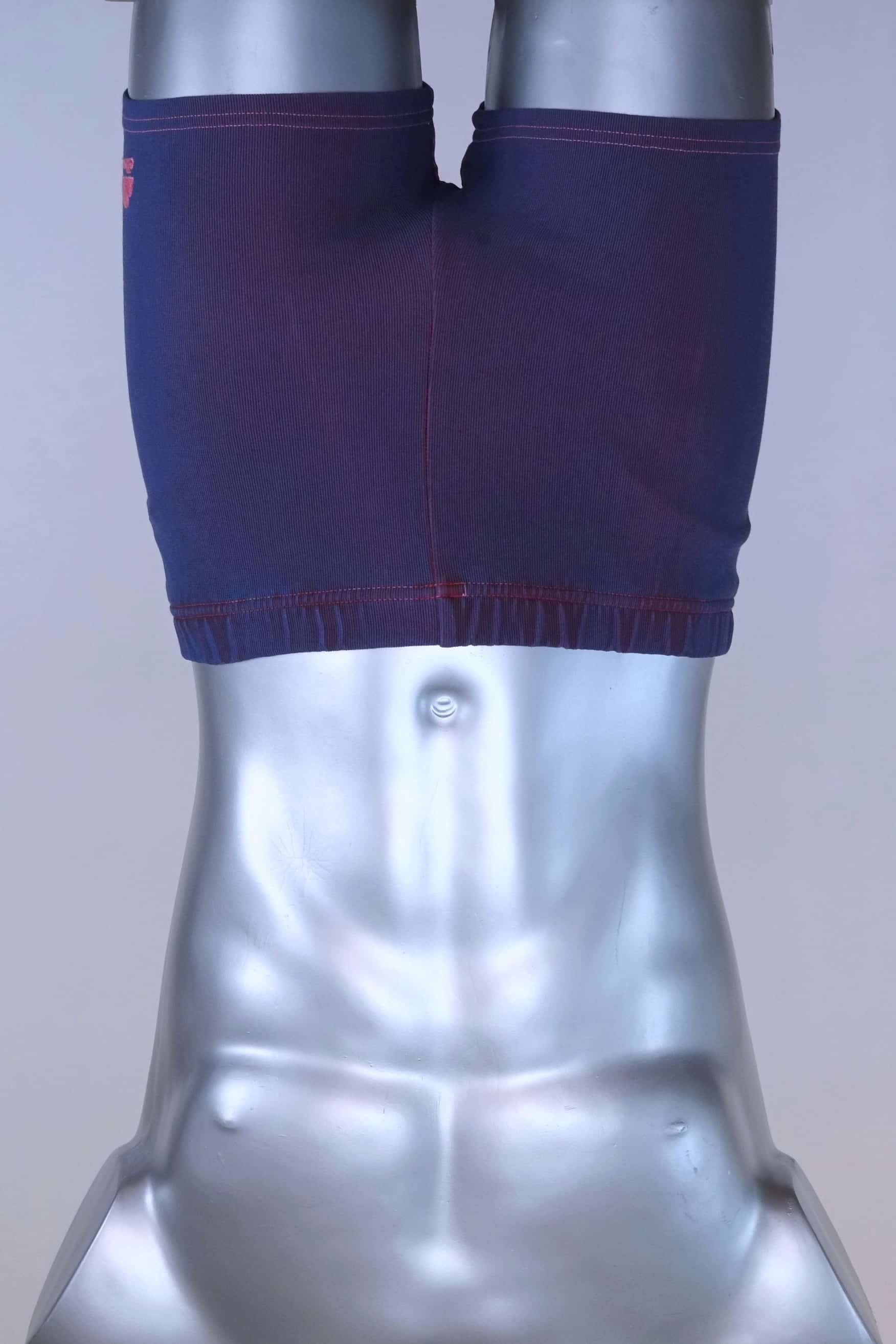 Vintage 90s Ellesse men’s swim trunks in deep purple ribbed stretch knit with pink contrast stitching, shown on a silver mannequin.