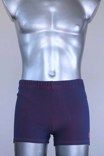 Vintage 90s Ellesse men’s swim trunks in deep purple ribbed stretch knit with pink contrast stitching, shown on a silver mannequin.