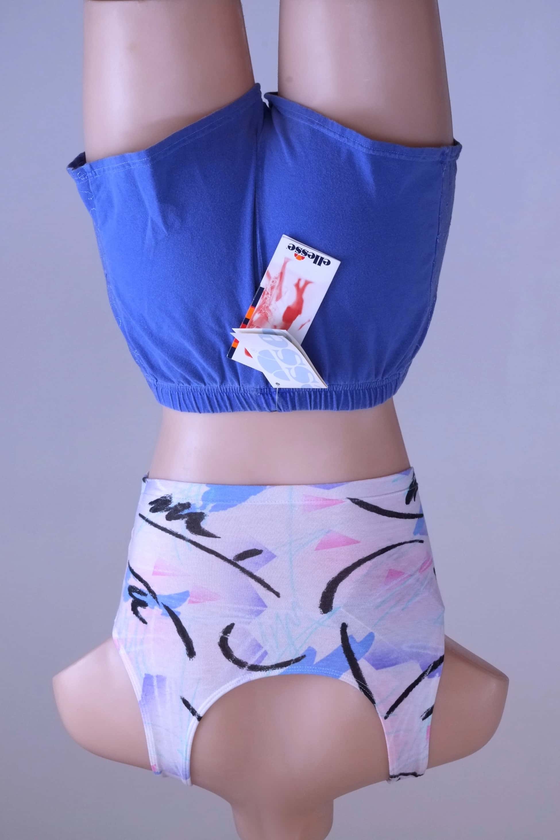 Back view of mannequin wearing vintage Ellesse embroidered terry hot pants in blue, with the tags showing.