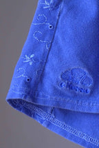 Detail of floral embroidery and Ellesse logo on vintage 90s terry cloth hot pants