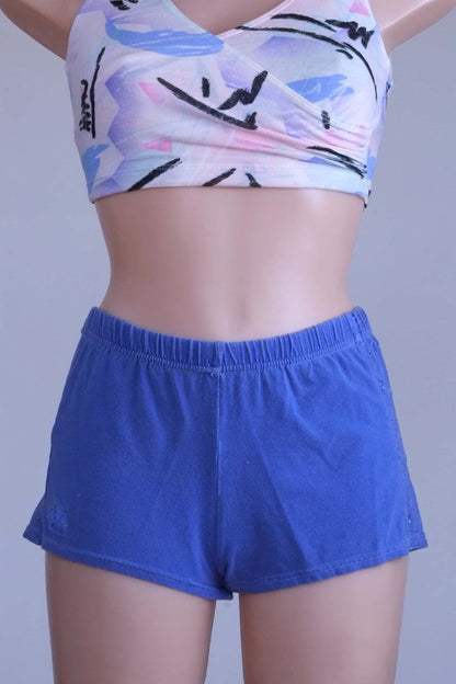 Front view of mannequin wearing vintage Ellesse embroidered terry hot pants in blue.