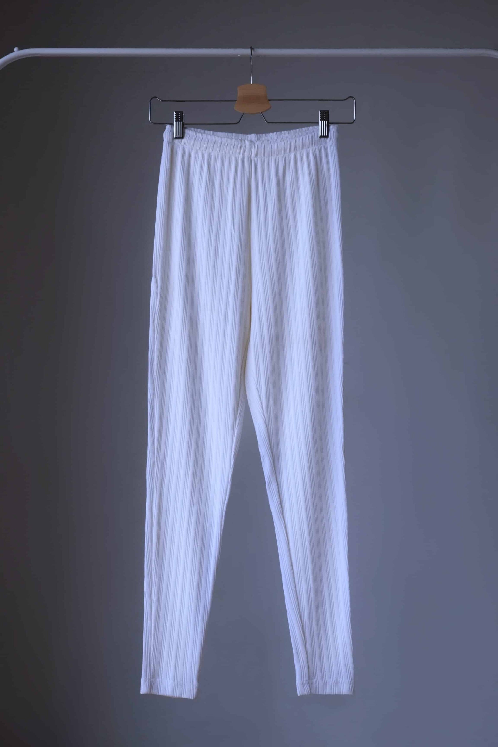 High-waisted, ribbed white leggings hanging on hanger.