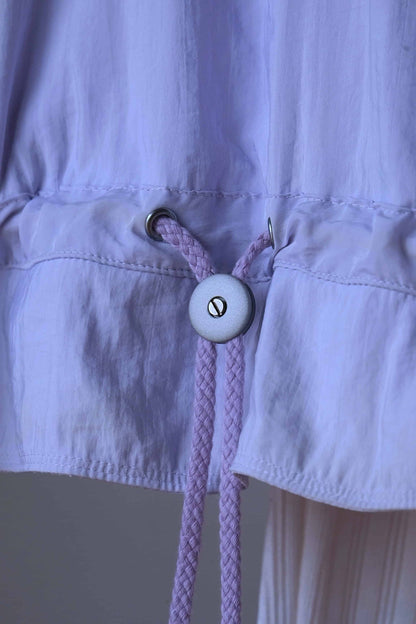 Detail of the drawstring closure on a Vintage Ellesse pastel purple jacket. 