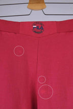 Close-up of the waistband of red Fila 90s vintage jogging pants, featuring the Fila logo in black, red, and blue.