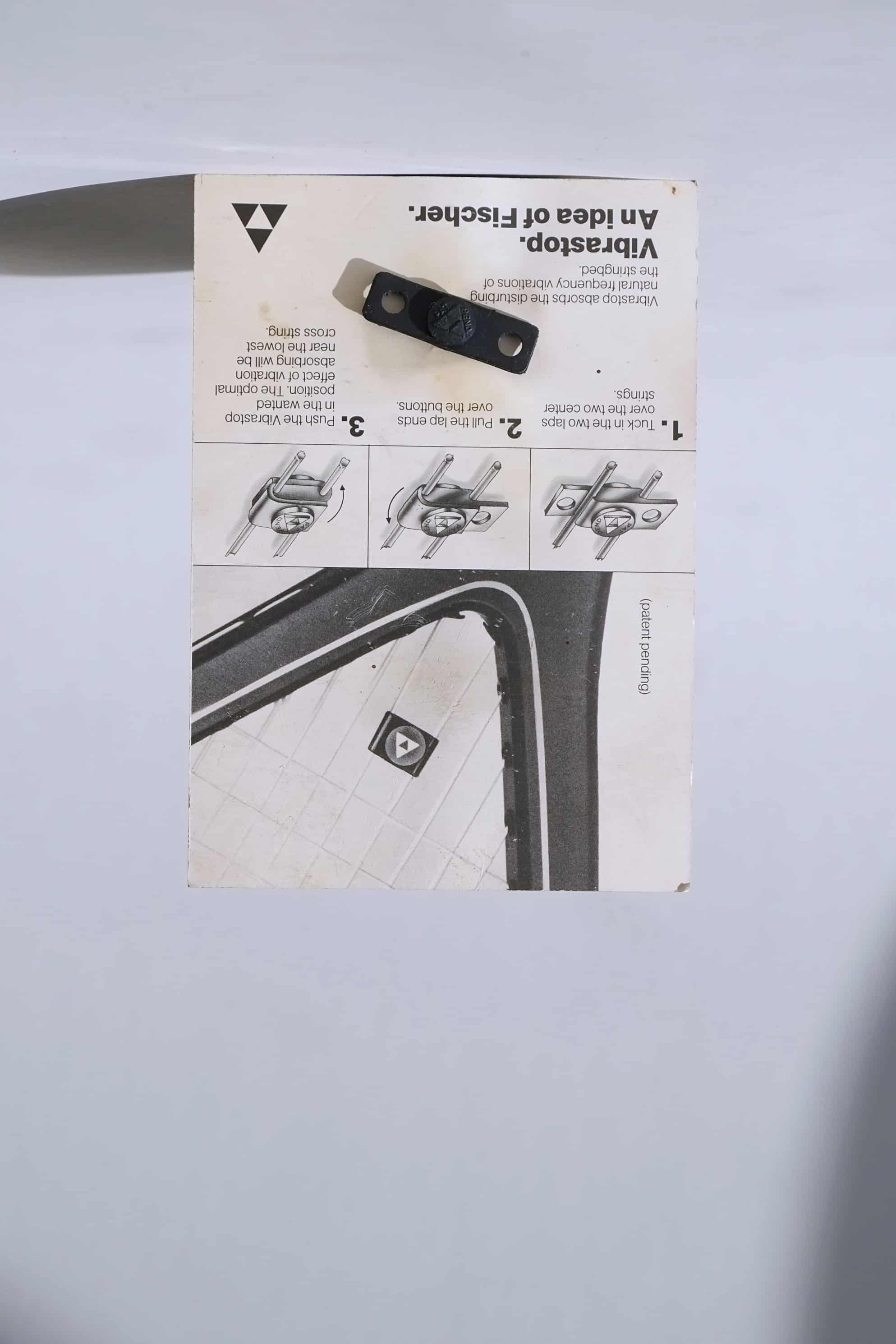 Back view of the vintage Fischer Vibrastop packaging, displaying illustrated step-by-step installation instructions for the racquet dampener.