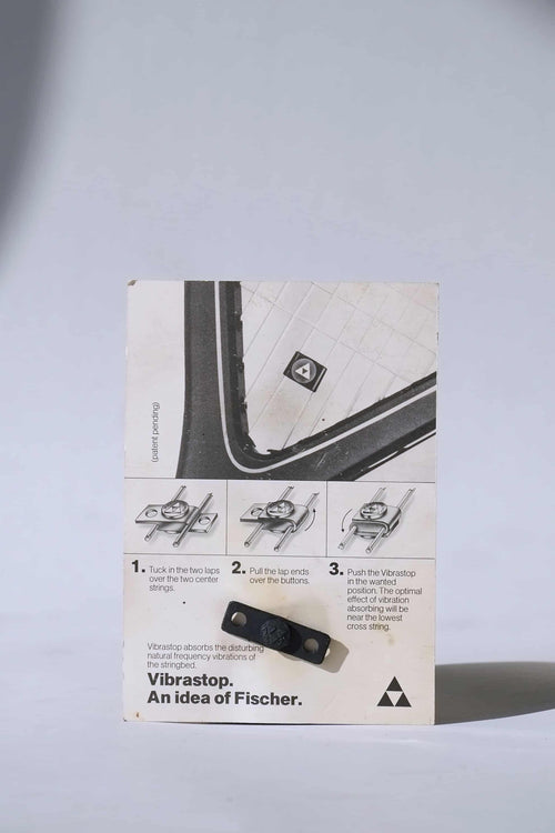 Back view of the vintage Fischer Vibrastop packaging, displaying illustrated step-by-step installation instructions for the racquet dampener.