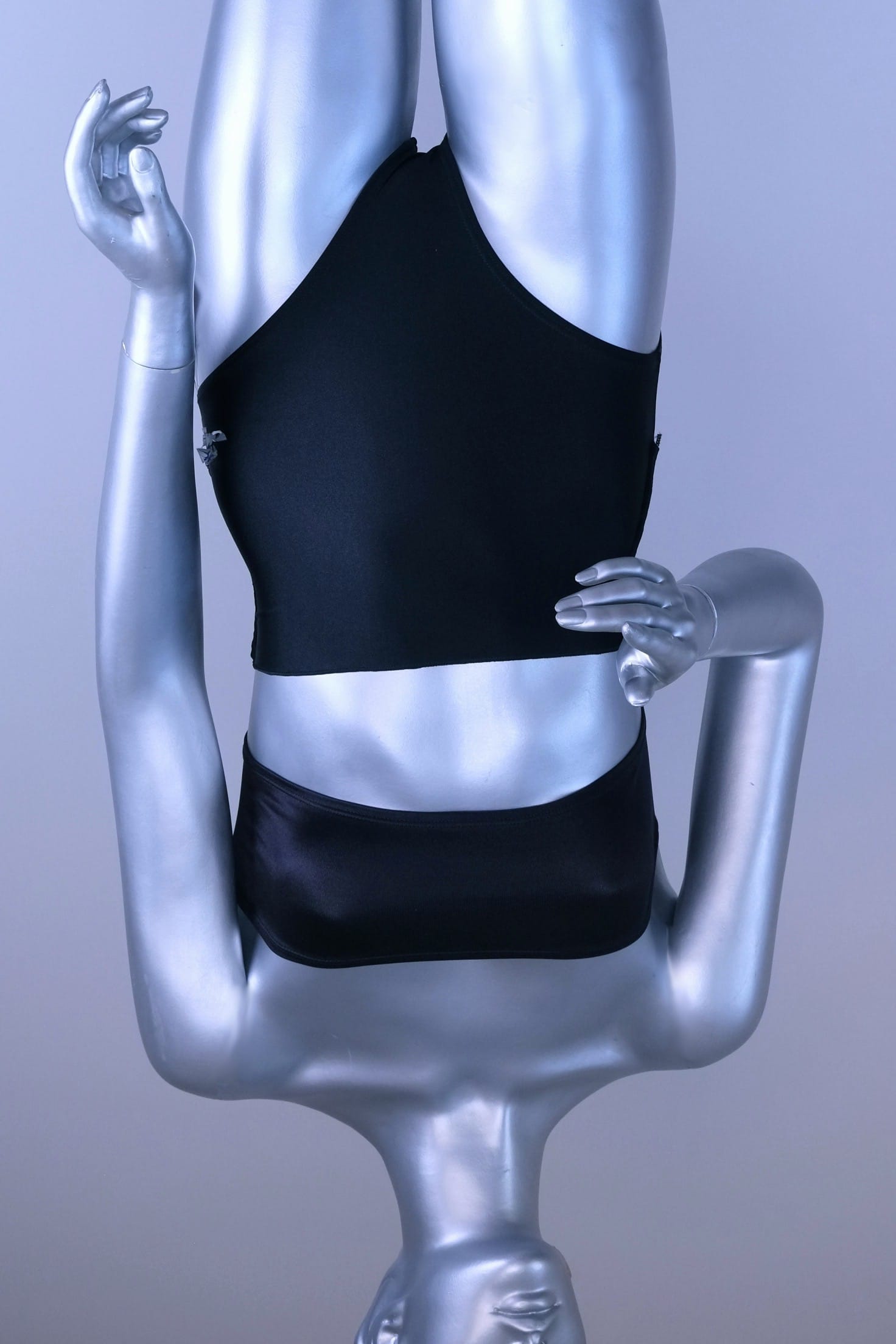Silver mannequin wearing a black tube top bra and black dance briefs against a gray background