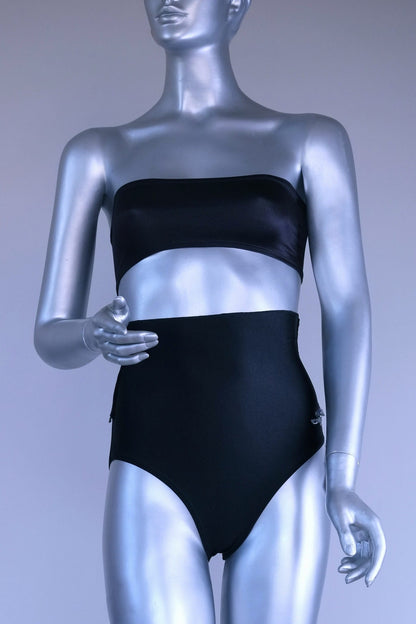 Silver mannequin wearing a black tube top bra and black dance briefs against a gray background