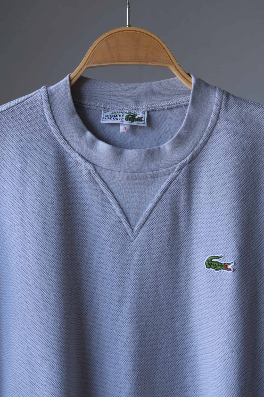 close up of Gray Lacoste 90s sweatshirt on hanger