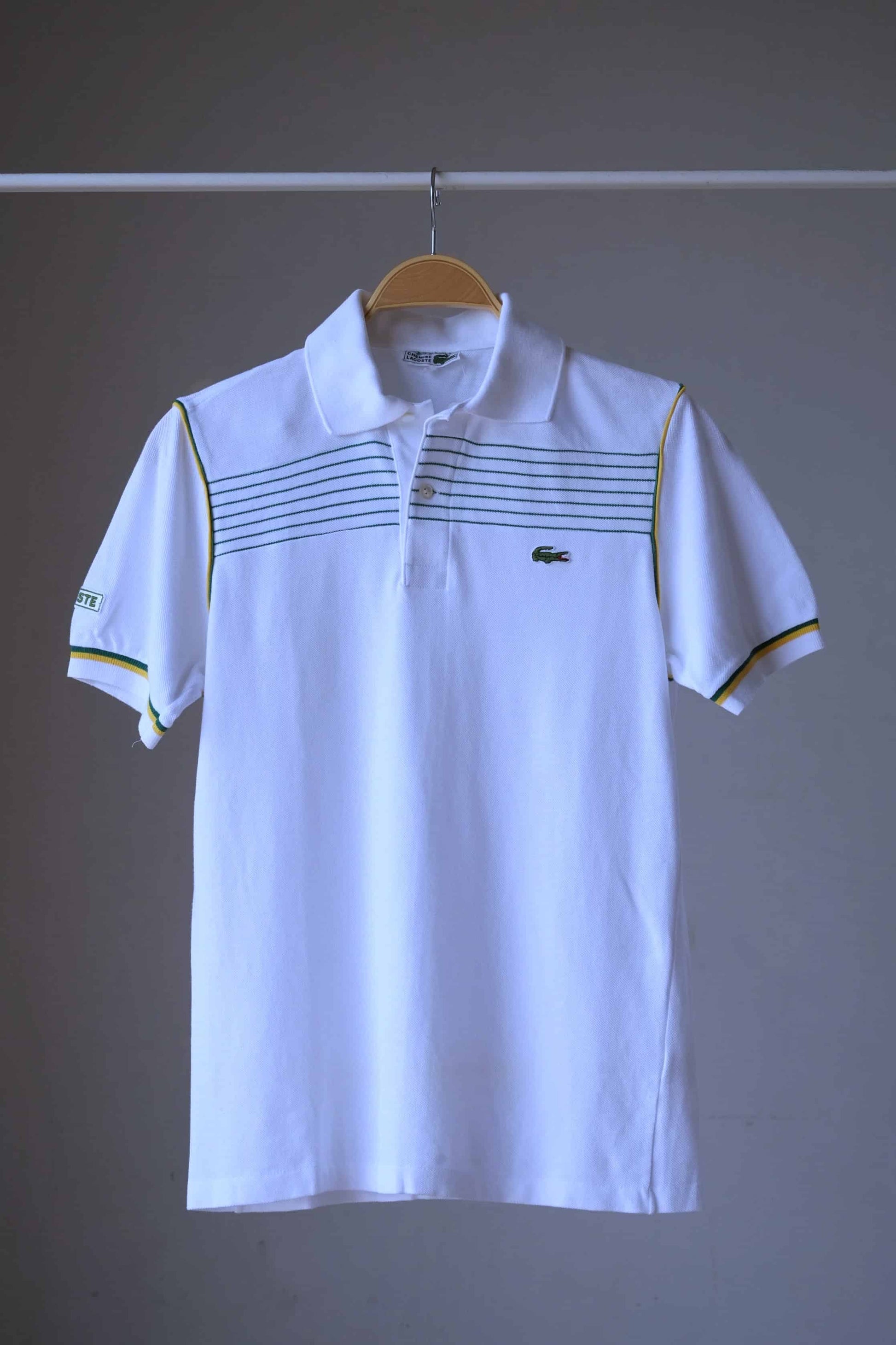 LACOSTE Retro Polo in white with yellow stripes and green edging photographed on hanger