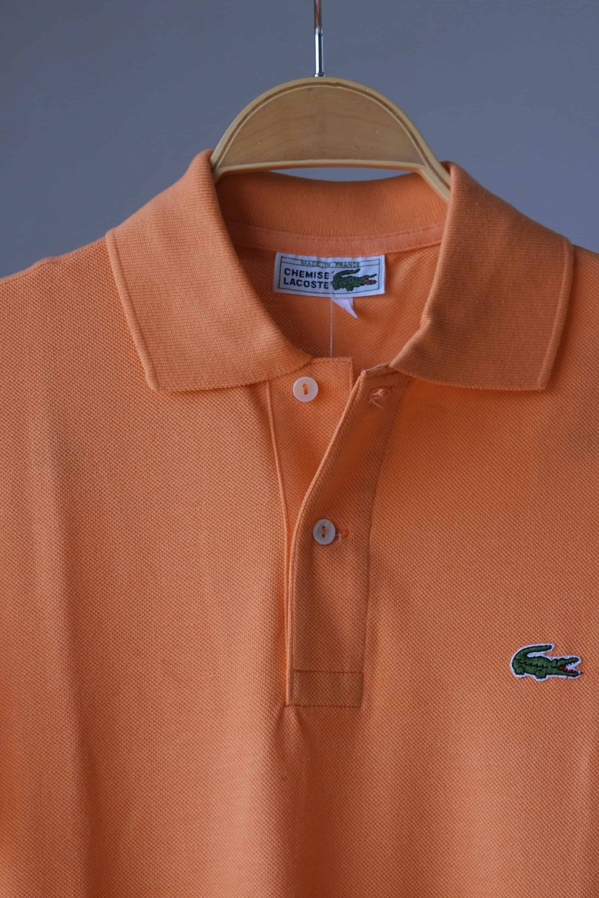 Close up of LACOSTE Retro Shirt in peach orange color