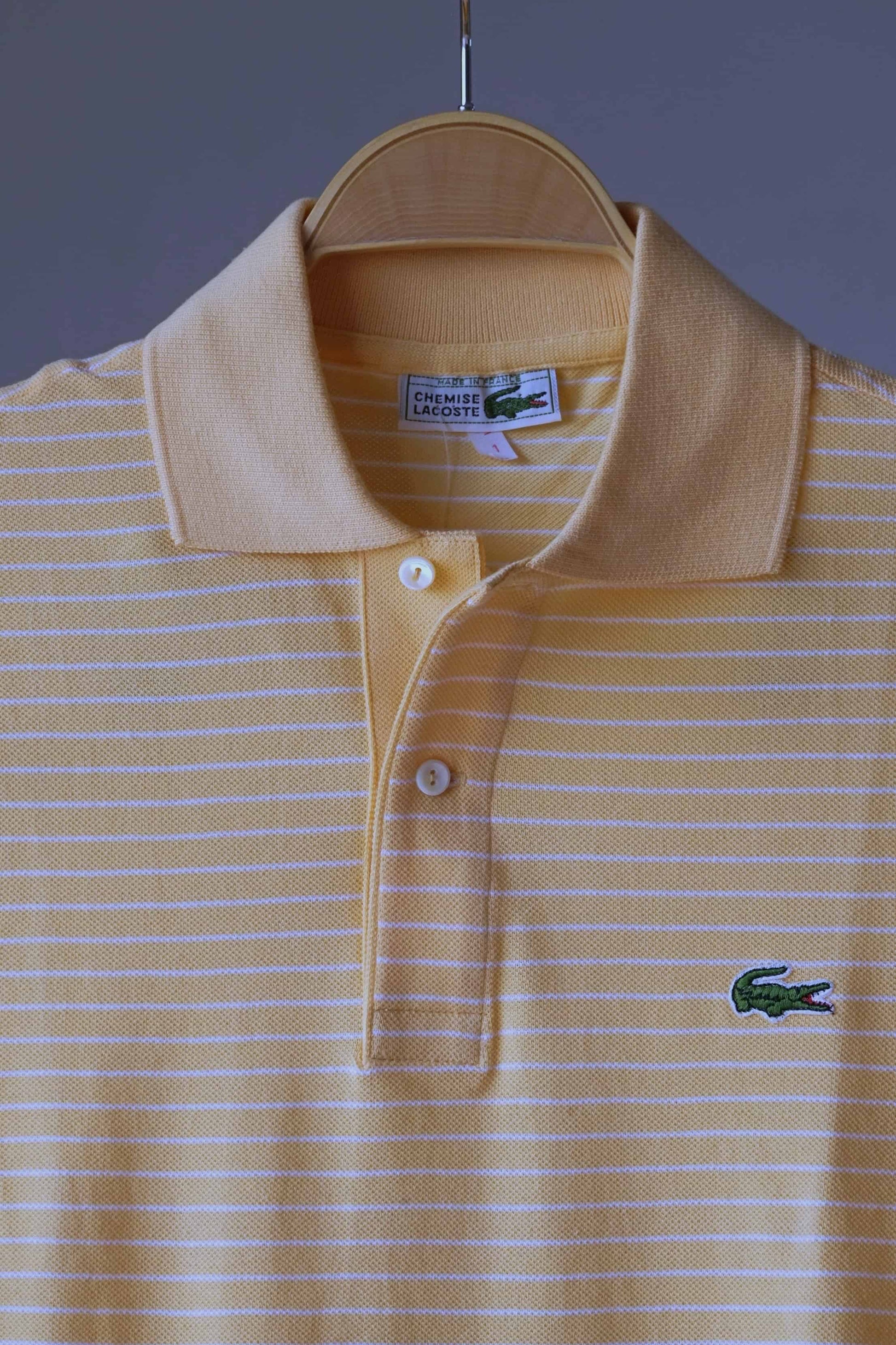 close up of LACOSTE Striped Polo in melon color with soft white stripes