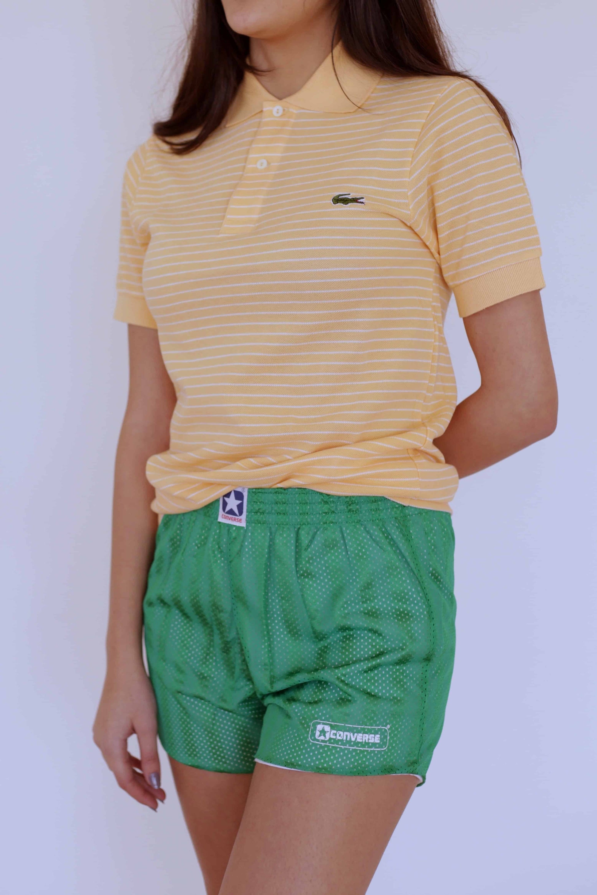 LACOSTE Striped Polo in melon color with white stripes worn with green shorts