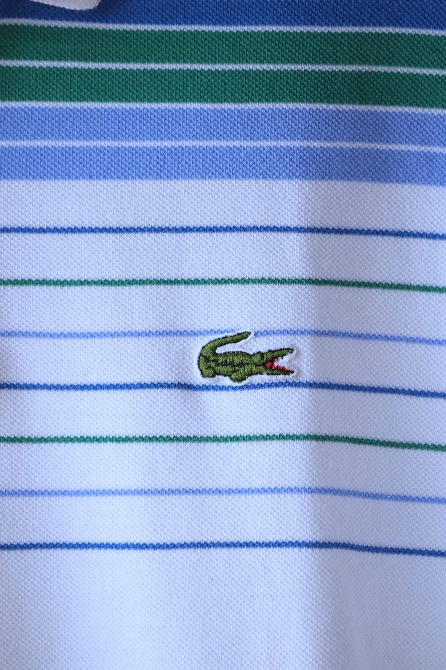 Close up of Lacoste crocodile logo on LACOSTE Vintage Striped Polo in white with green and blue stripes