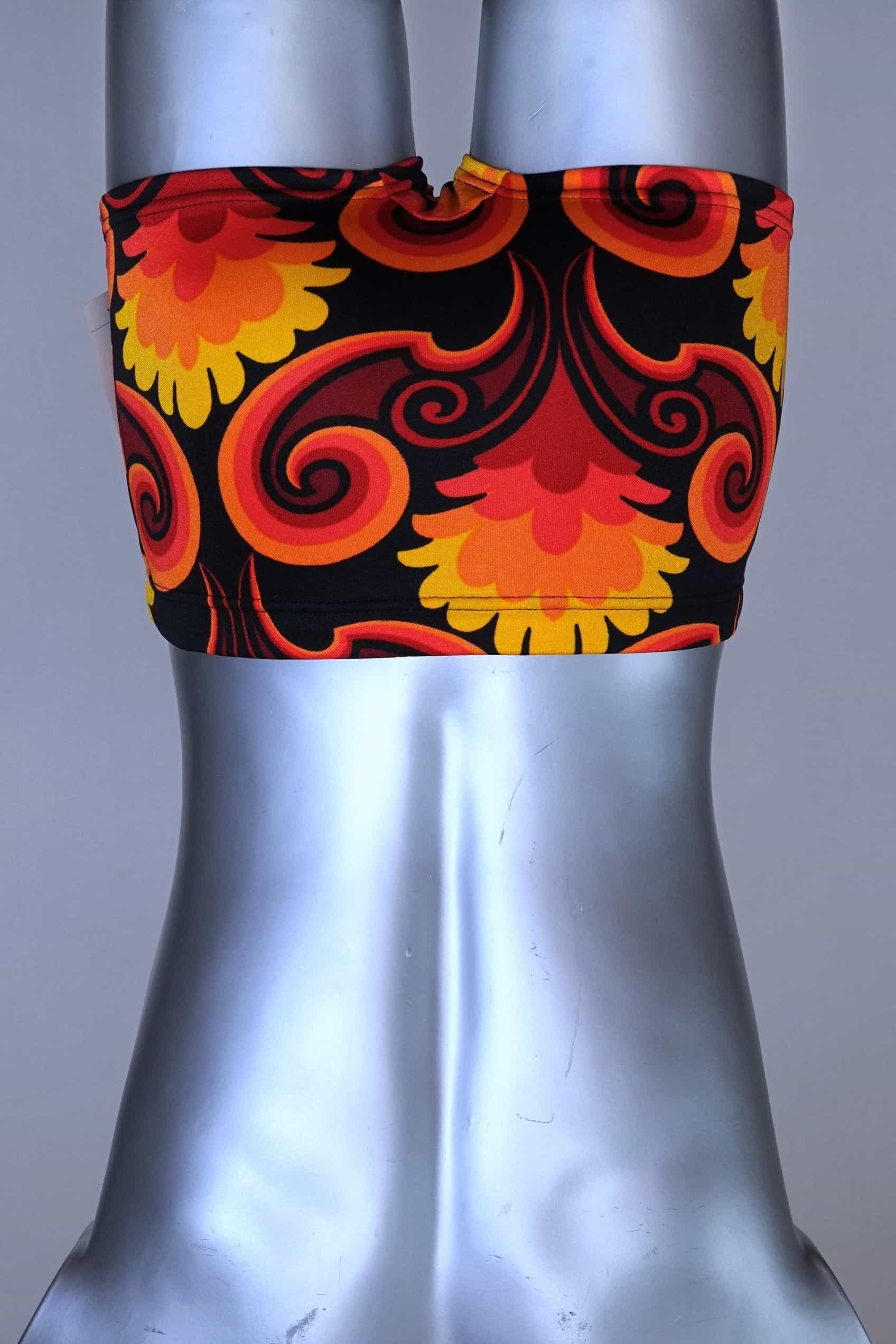 Back view of LAHCO vintage 60s square-cut swim trunks in a red, orange, and yellow psychedelic floral print, shown on a mannequin with original tag.