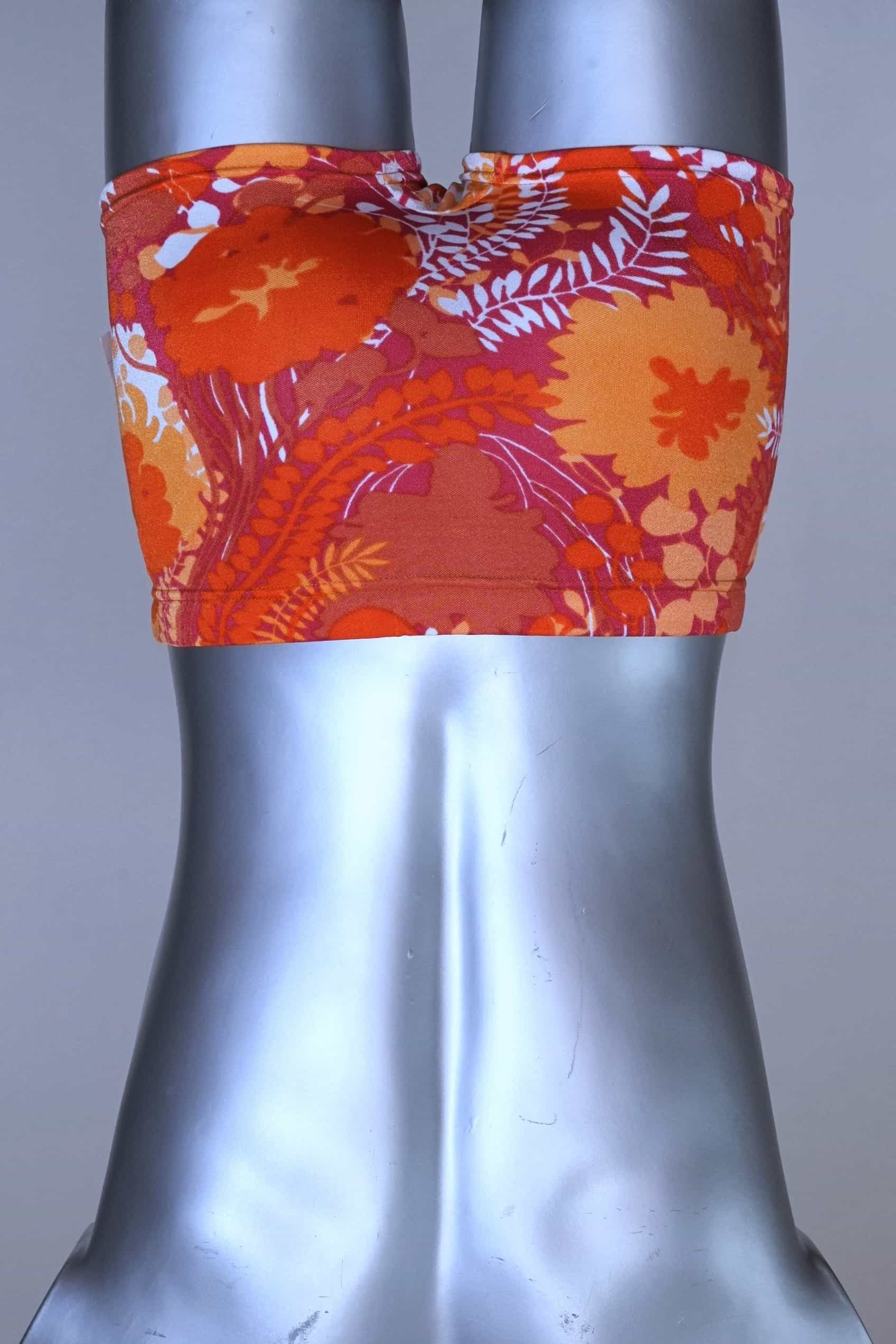 Back view of LAHCO vintage 60s “Rovigo” swim trunks with orange, red, and white floral print, shown on mannequin with original tag.