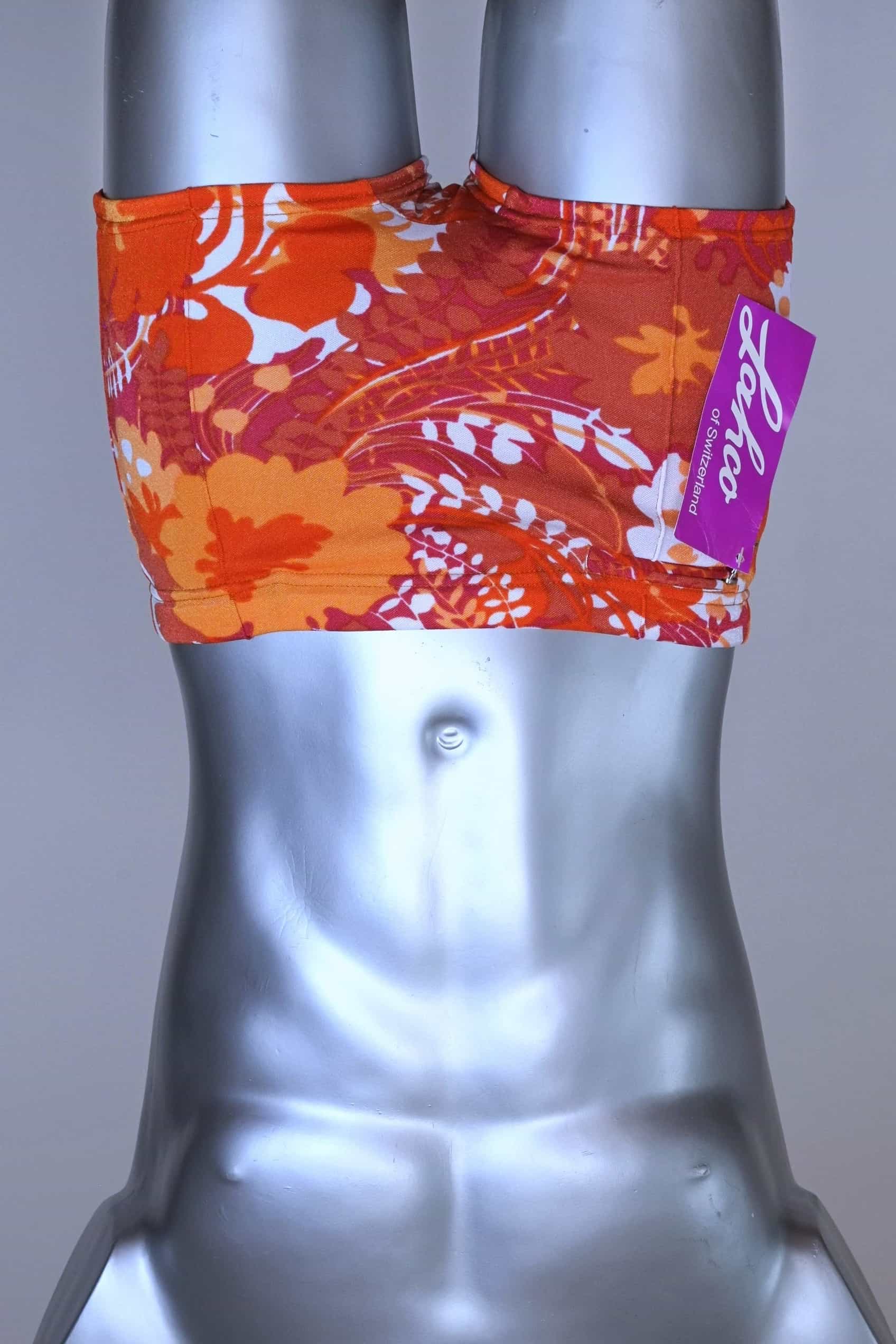 Front view of LAHCO vintage 60s “Rovigo” swim trunks with orange, red, and white floral print, shown on mannequin with original tag.