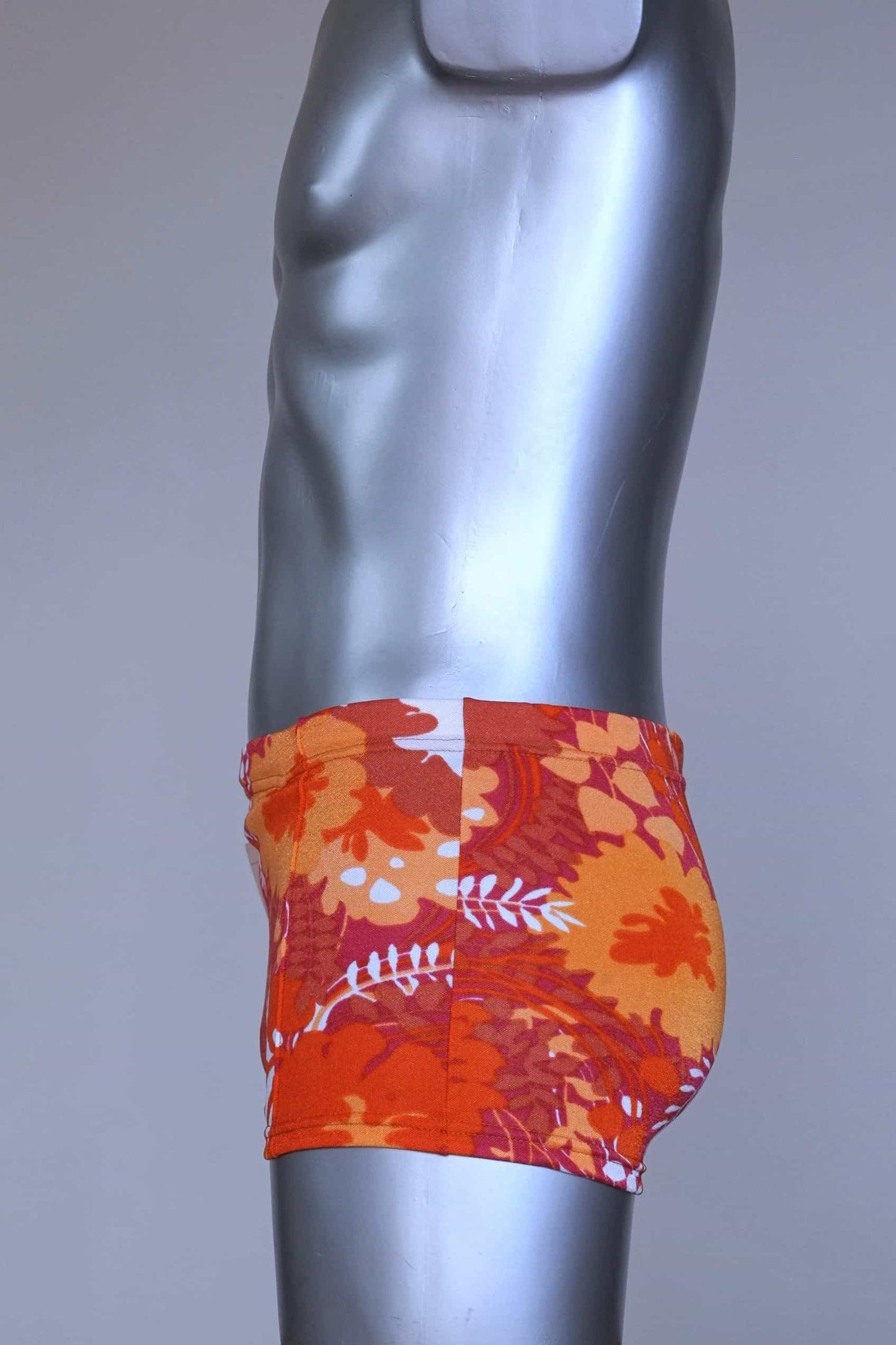 Side view of LAHCO vintage 60s “Rovigo” swim trunks with orange, red, and white floral print, shown on mannequin.