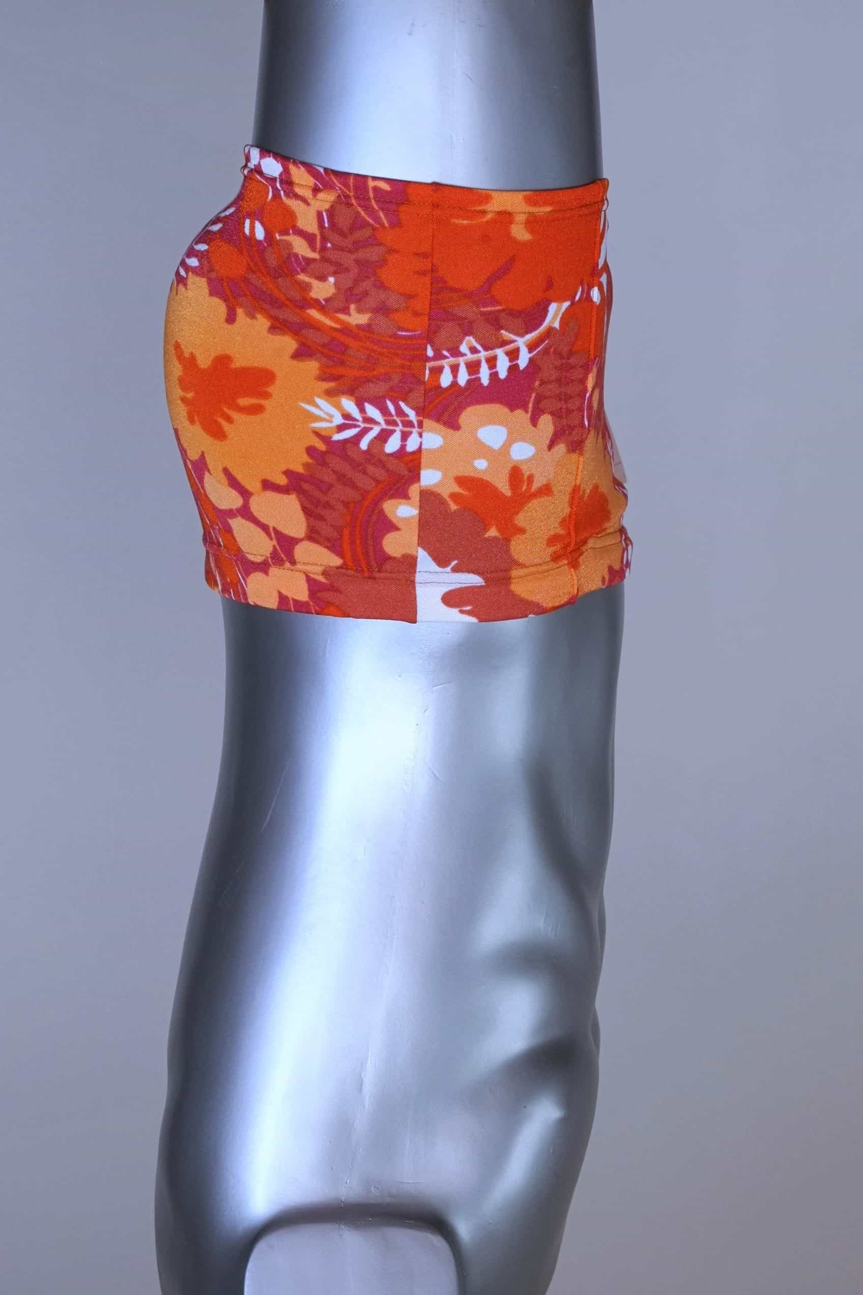 Side view of LAHCO vintage 60s “Rovigo” swim trunks with orange, red, and white floral print, shown on mannequin.