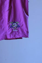 Close-up of the embroidered geometric "Big Point by Löffler" logo on magenta vintage 90s Tactel nylon tennis shorts.