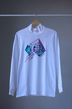 Front view of white Löffler 90s mock neck long-sleeve tennis top with a pink, teal and purple “Start the Craze” graphic and Transtex collar embroidery