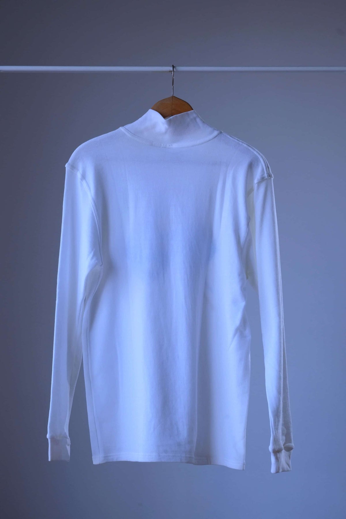 Back view of a white Löffler 90s mock neck long-sleeve top with ribbed cuffs and visible shoulder seams, plain back with no print