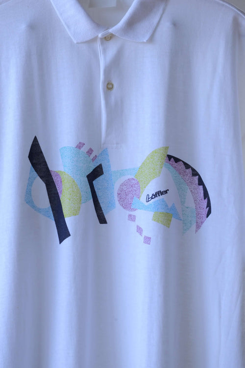 Close-up of the Löffler Memphis print on a white 90s polo, with geometric shapes, a Löffler logo and a two-button placket