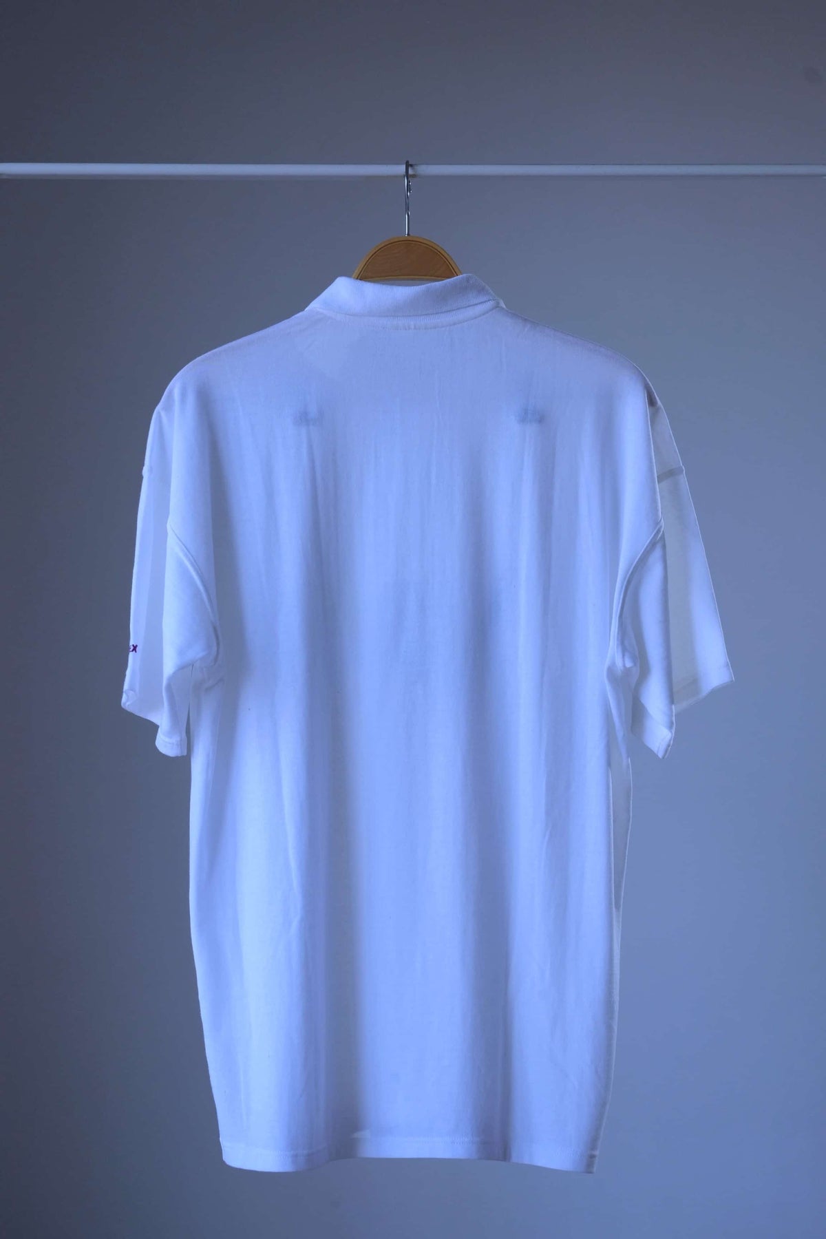 Back of the vintage Löffler Memphis print tennis polo, plain white with a ribbed polo collar and short sleeves