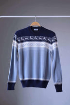Löffler brand navy and light blue wool blend sweater featuring a white Nordic pattern with reindeer and snowflake motifs, hanging on a wooden hanger against a plain background.