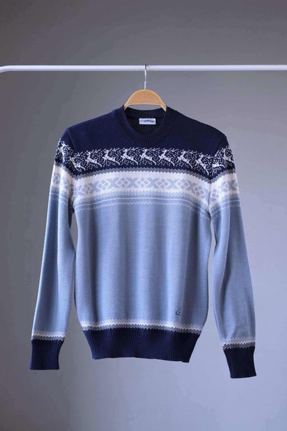 Löffler brand navy and light blue wool blend sweater featuring a white Nordic pattern with reindeer and snowflake motifs, hanging on a wooden hanger against a plain background.