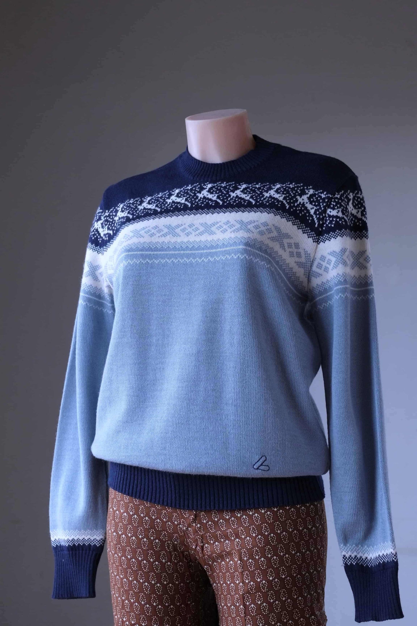 Löffler brand navy and light blue wool blend sweater featuring a white Nordic pattern with reindeer and snowflake motifs, worn by a mannequin.