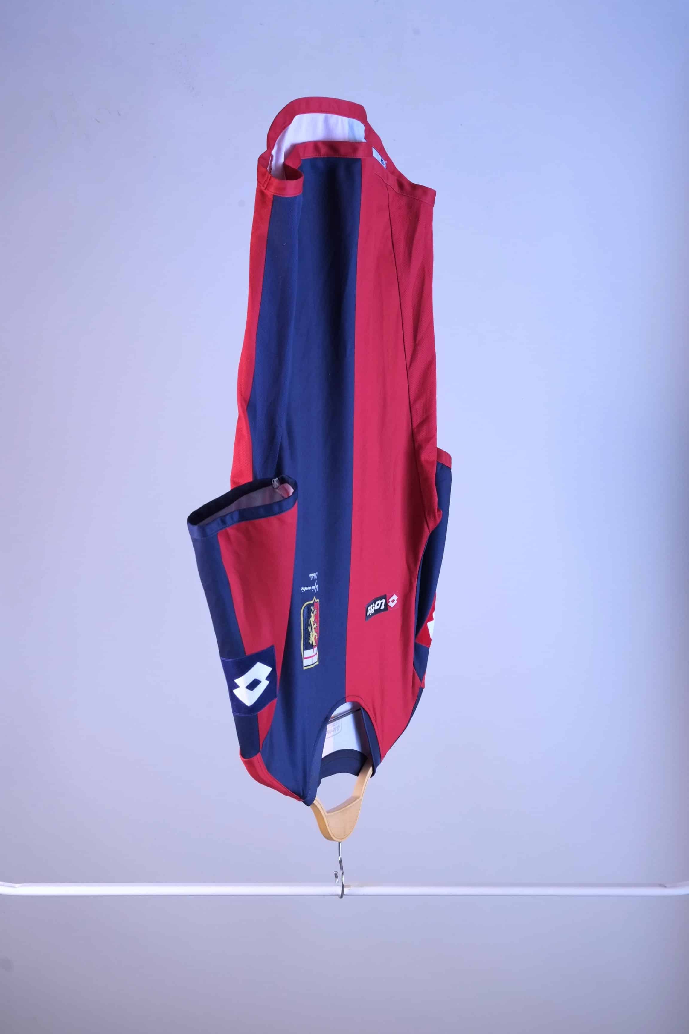 Side-angle view of the red and navy blue football jersey hanging on a wooden hanger, showing the fit and sleeve construction.