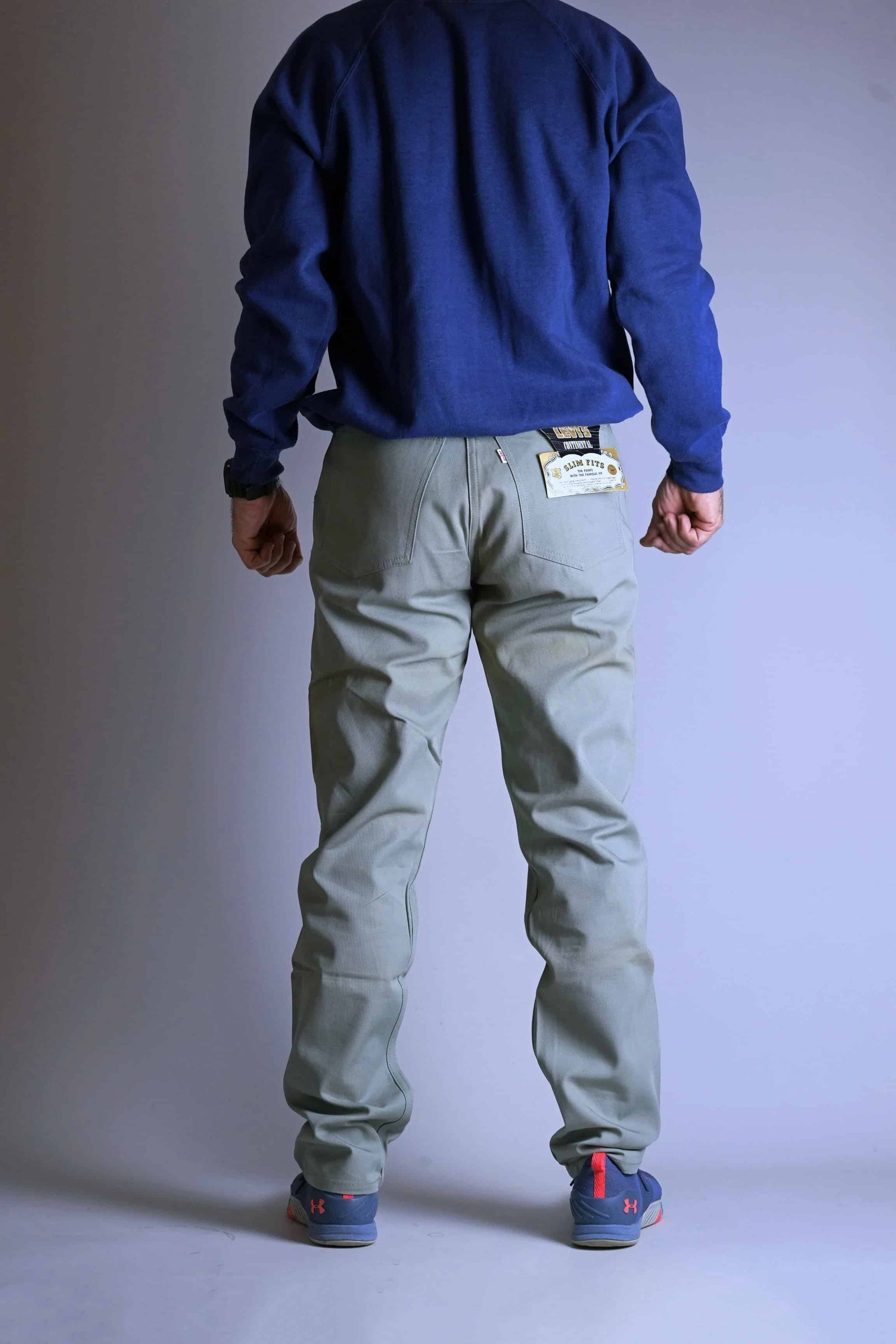 Full back view of a model wearing the Vintage Levi's Continental Slim Fit Chinos, showing the overall tailored silhouette and the original tags hanging from the waistband.