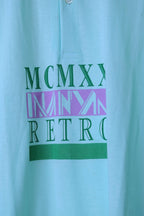 Close-up of the MCMXX Retro graphic on a mint green Löffler 90s polo, with green serif lettering, a lilac band and a solid green bar