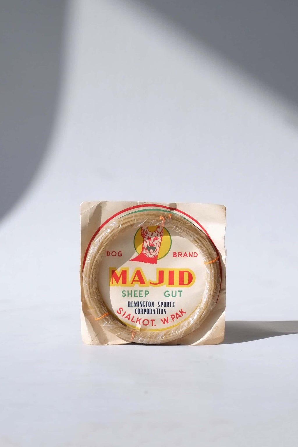 Deadstock vintage Majid Dog Brand natural sheep gut tennis strings in their original paper packaging from Sialkot, West Pakistan.