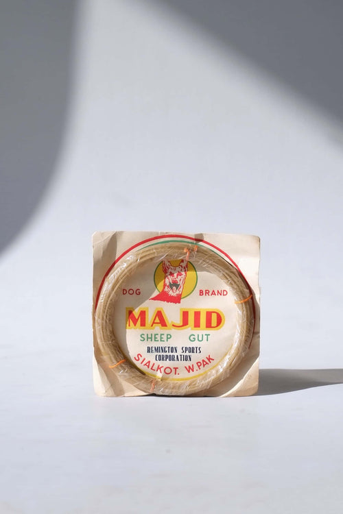Deadstock vintage Majid Dog Brand natural sheep gut tennis strings in their original paper packaging from Sialkot, West Pakistan.