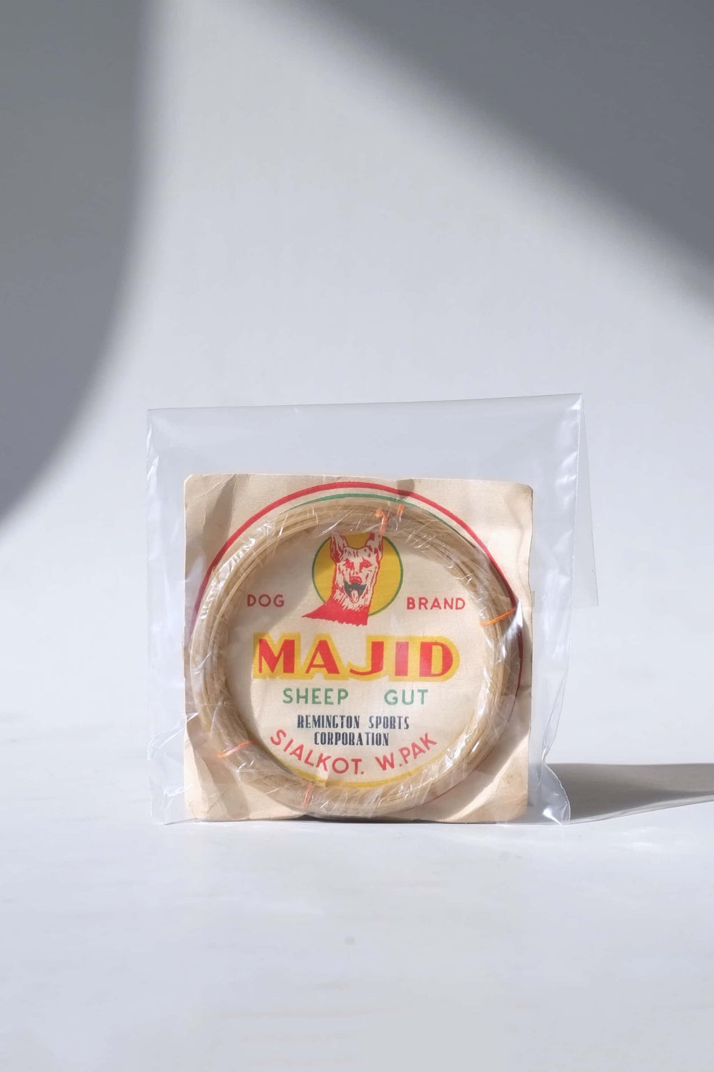 Vintage pre-1971 Majid Dog Brand organic sheep gut racket strings, sealed inside a protective clear collector's sleeve.