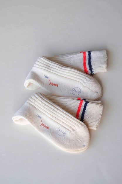 Vintage off-white wool socks with red and navy stripes on white background