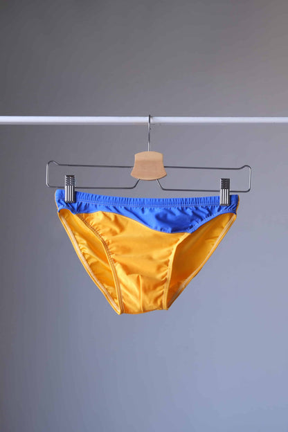 Vintage 80's Swim Briefs Low Rise with Bold Blue & Yellow displayed on a hanger.