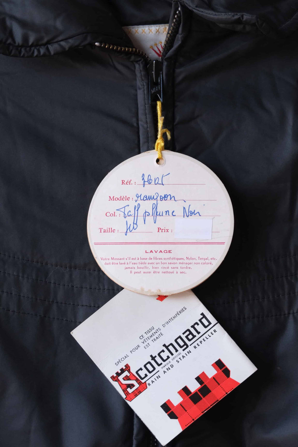 Close up of the original hangtags  of the Mossant jacket. The tag lists the model as "Rangoon," the color as "Noir" (Black), and the size as 40, with French care instructions printed below.