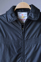 Detail of the upper chest area of the black vintage Mossant Rangoon  jacket, highlighting the horizontal multi-stitch quilted pattern and the metallic zipper.