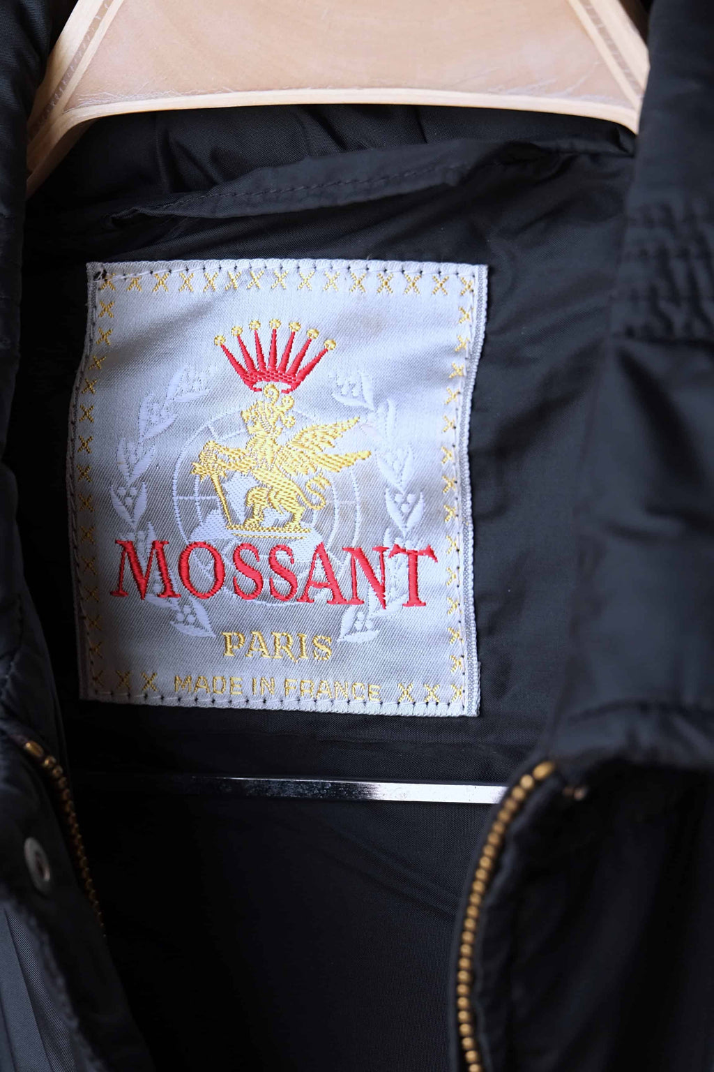 A white woven vintage neck label for Mossant Paris, featuring a gold crest with a red crown and "Made in France" text in gold.
