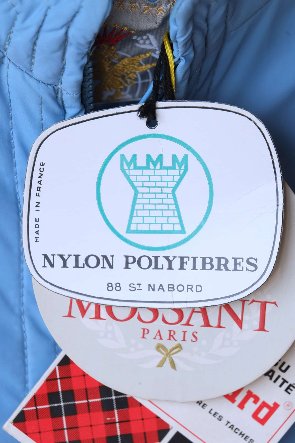 Close-up of the original vintage tags on the jacket, including a white "Nylon Polyfibres" tag made in France and a circular "Mossant Paris" brand label.